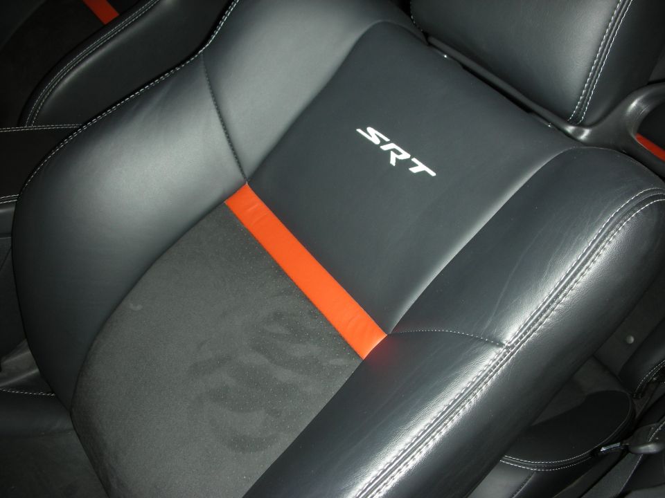 Black car seat with orange stripe and white SRT stitching