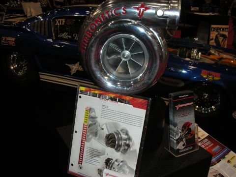 1998 Ford Crown Victoria - A large Turbonetics turbocharger is prominently displayed on a blue classic car at a show.