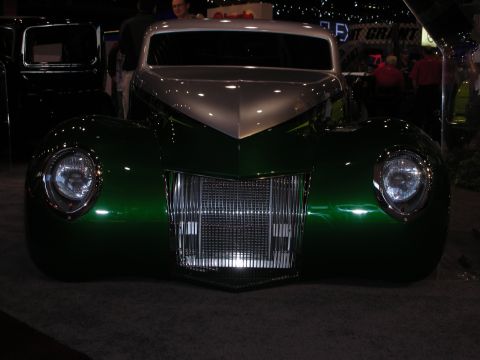 1998 Ford Crown Victoria - A two-tone green and silver customized hot rod is displayed with a prominent chrome grille and round headlights.
