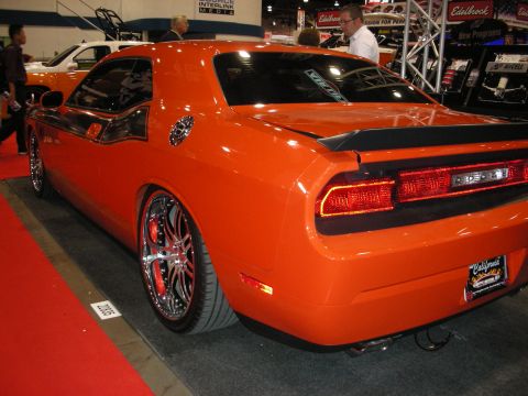 1998 Ford Crown Victoria - This orange Dodge Challenger features custom chrome wheels and a rear spoiler, with its distinctive LED taillights glowing.