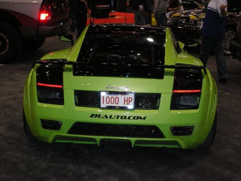 1998 Ford Crown Victoria - A lime green sports car is seen from the rear, displaying a license plate that reads '1000 HP' and the website ZRAUTO.COM.