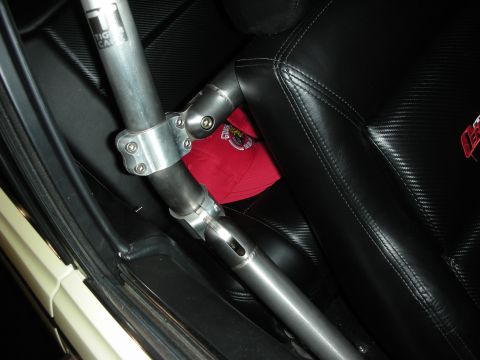 1998 Ford Crown Victoria - Interior view of a car's roll cage with black leather seats and a red hat.