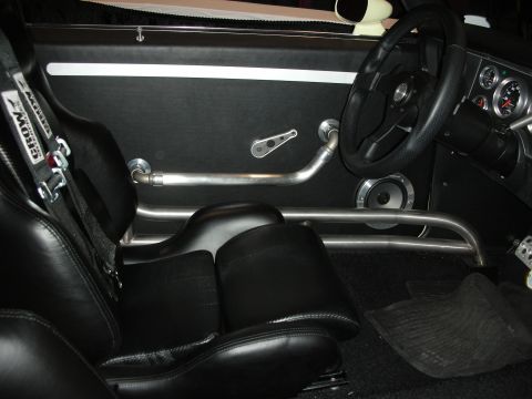 1998 Ford Crown Victoria - The interior features racing seats, a roll cage, and a custom door panel with a speaker.