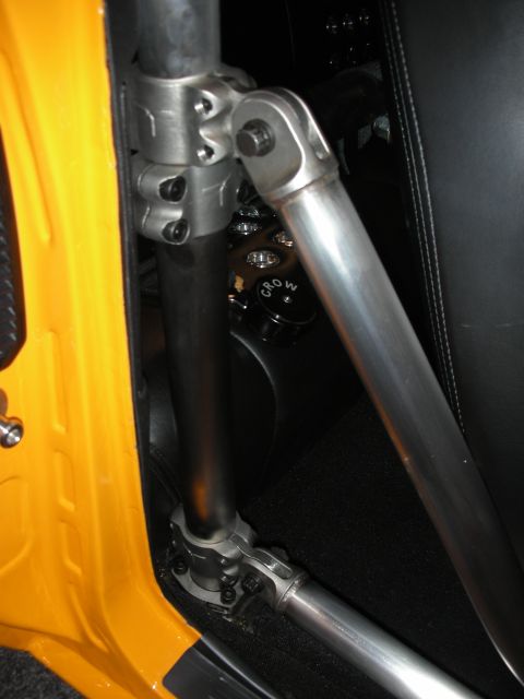 1998 Ford Crown Victoria - Close-up of a vehicle's interior showing a roll cage and a black cap labeled 'CROW'.