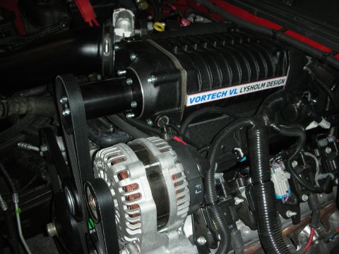 1998 Ford Crown Victoria - Engine bay detail showing a supercharger and alternator assembly with visible text on the supercharger casing.