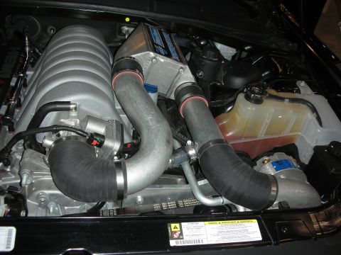 1998 Ford Crown Victoria - Close-up view of a supercharged engine bay, showing intake piping and coolant reservoir.