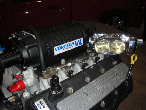1998 Ford Crown Victoria - Close-up of a Ford engine a Vortech VL supercharger and "POWERED BY SVT" branding on the valve cover.