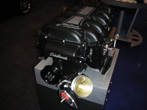 1998 Ford Crown Victoria - This Edelbrock supercharger is displayed on a stand, showing off its intricate components.
