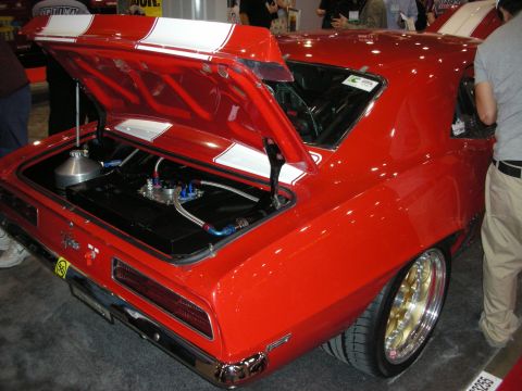 1998 Ford Crown Victoria - A red 1969 Chevrolet Camaro is displayed with its trunk open, revealing a custom fuel cell and racing stripes.