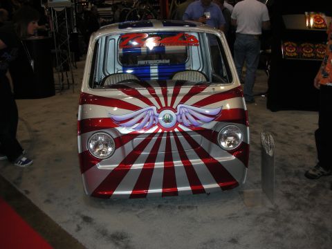 1998 Ford Crown Victoria - This custom van features a striking red and silver sunburst graphic with wings on its front.