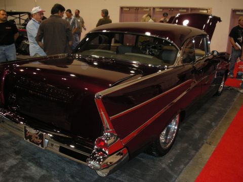 1998 Ford Crown Victoria - Custom 1957 Chevrolet Bel Air with a deep metallic red finish and chrome accents is displayed indoors.