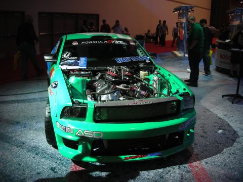 1998 Ford Crown Victoria - Custom green Ford Mustang with engine exposed at an event. "Ready to Rock" sticker on windshield.