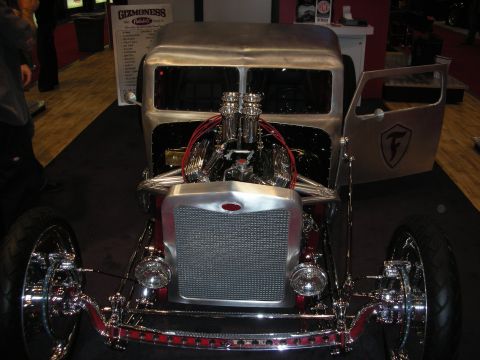 1998 Ford Crown Victoria - Custom hot rod truck with a prominent V8 engine and polished aluminum bodywork on display.