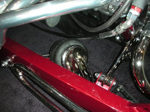 1998 Ford Crown Victoria - Detail shot of a custom hot rod's suspension system, polished chrome and a vibrant red frame.