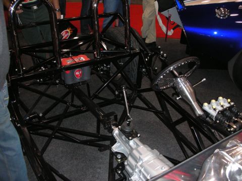 1998 Ford Crown Victoria - The bare frame of a custom vehicle is shown, highlighting its mechanical components and roll cage.