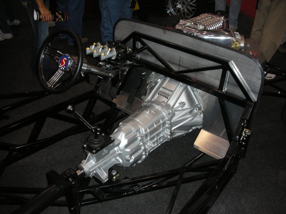 Drag racing chassis with supercharged V8 engine, transmission, and steering wheel