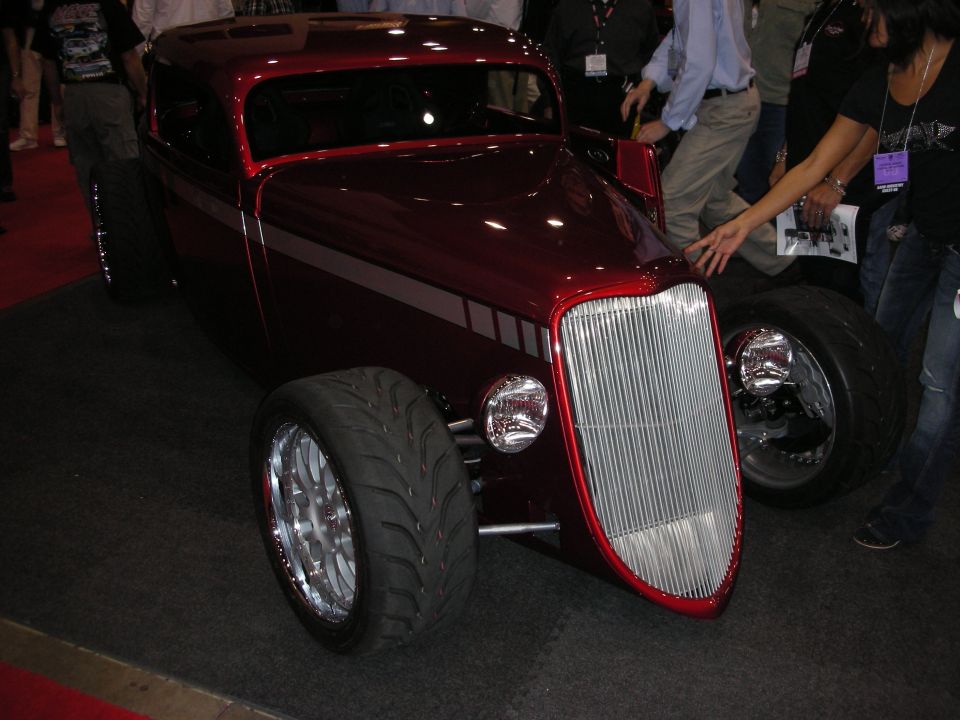 Red custom hot rod coupe with chrome grille and wide tires