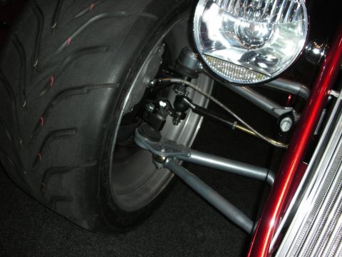 1998 Ford Crown Victoria - The intricate front suspension and large headlight of a custom vehicle are shown in detail.