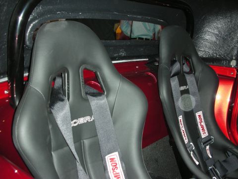 1998 Ford Crown Victoria - Close-up of racing seats with Simpson harnesses and Cobra branding, suggesting a performance-oriented interior.