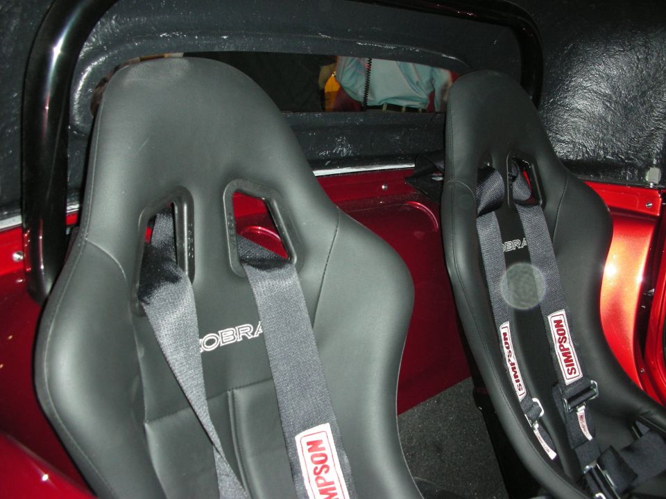 Interior view of racing seats with Simpson harnesses and Cobra branding