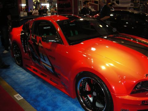 1998 Ford Crown Victoria - This modified Ford Mustang features custom graphics and racing seats, displayed indoors on a blue carpet.