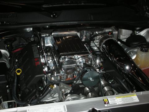 1998 Ford Crown Victoria - Close-up view of a highly modified 6.1L Hemi engine a prominent supercharger and polished intake piping.