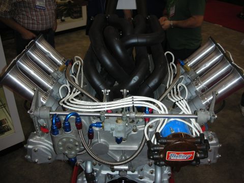1998 Ford Crown Victoria - Close-up of a high-performance engine four silver intake stacks and a Mallory Ignition distributor, likely on display at an automotive even…