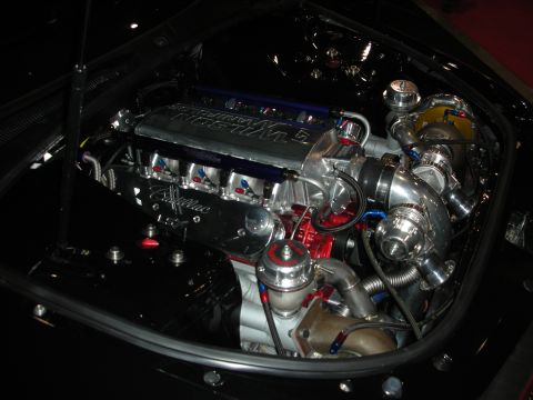 1998 Ford Crown Victoria - A highly modified V8 engine with twin turbochargers is displayed, Cadillac LS valve covers.
