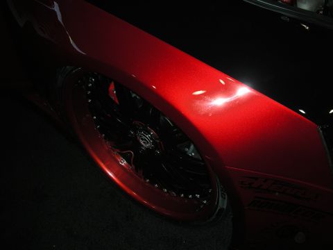 1998 Ford Crown Victoria - Close-up of a custom red fender and wheel on a dark vehicle.