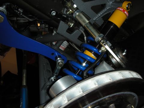 1998 Ford Crown Victoria - Close-up of aftermarket suspension components including a blue control arm and a yellow Koni shock absorber.
