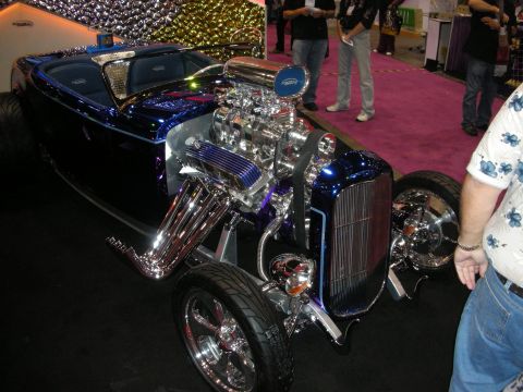 1998 Ford Crown Victoria - A custom hot rod with a powerful chrome engine and vibrant blue paint is displayed indoors.