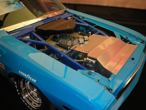 1998 Ford Crown Victoria - The engine bay of a blue race car is shown, a roll cage and Goodyear tires.