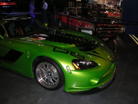 1998 Ford Crown Victoria - A bright green Dodge Viper is parked indoors, with other vehicles visible in the background.