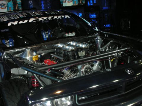1998 Ford Crown Victoria - The engine compartment of a modified car, showing custom parts and a roll cage.