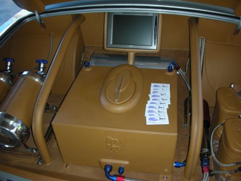 1998 Ford Crown Victoria - Custom trunk setup air ride components, a screen, and a prominent Rolls-Royce emblem on a storage box.