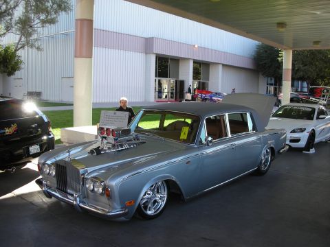 1998 Ford Crown Victoria - A heavily modified Rolls-Royce with a prominent supercharger is displayed at an outdoor event.