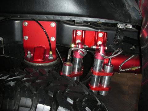 1998 Ford Crown Victoria - Close-up view of custom red air suspension components mounted near a large tire.
