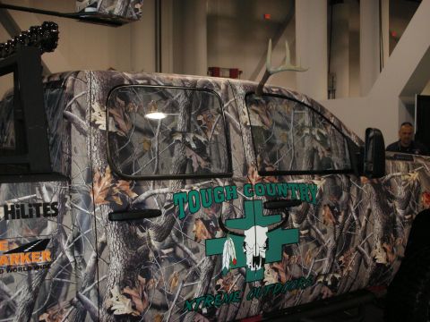 1998 Ford Crown Victoria - A camouflaged truck is seen with "Tough Country Xtreme Outdoors" branding and deer antlers protruding from the roof.