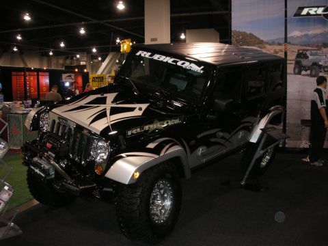 1998 Ford Crown Victoria - Black Jeep Wrangler with "Rubicon Express" branding and custom graphics displayed indoors.