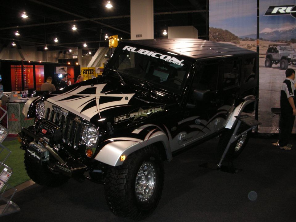 Black Jeep Wrangler with "Rubicon Express" windshield banner and custom graphics on hood and sides