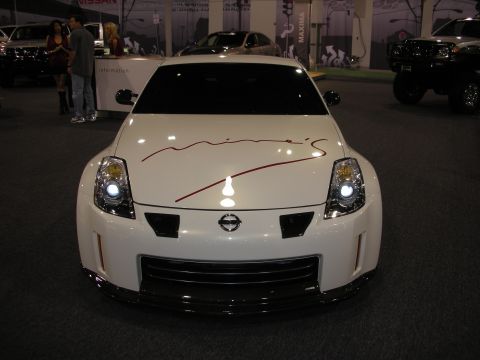 1998 Ford Crown Victoria - A white Nissan 350Z is displayed with red racing stripes on its hood.