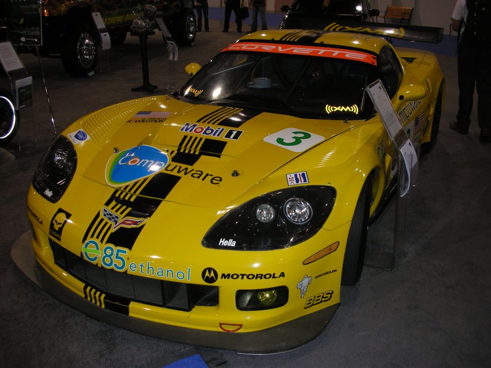 Yellow racing Corvette with 'Corvette' windshield banner, 'Compuware', 'Mobil 1', and 'ethanol' decals. Number 3 on hood