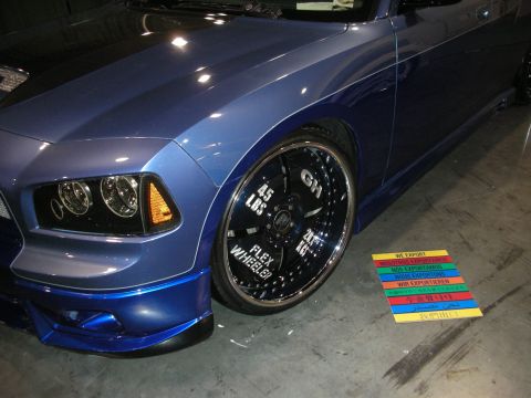 1998 Ford Crown Victoria - Custom blue car with large chrome rims 'Flex Wheeler' text and export information on the floor.