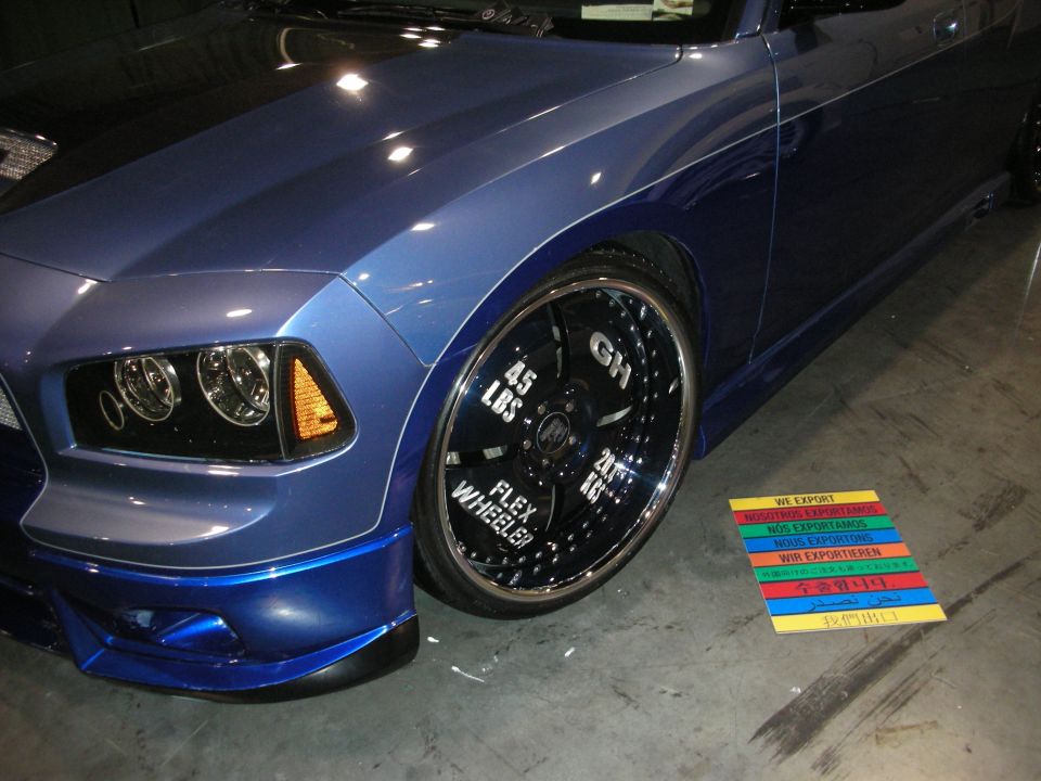 Blue car with custom rims that say 'Flex Wheeler'
