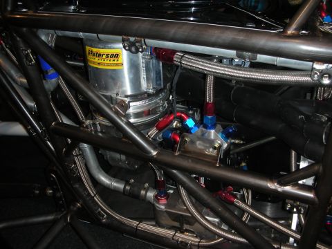 1998 Ford Crown Victoria - Custom fuel system components are visible within the intricate roll cage of a race car.