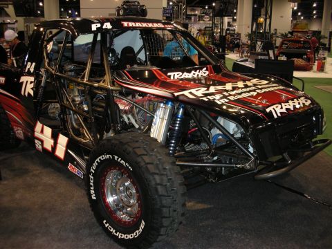 1998 Ford Crown Victoria - This custom off-road buggy features extensive roll cage and Traxxas branding, suggesting it is a display vehicle.