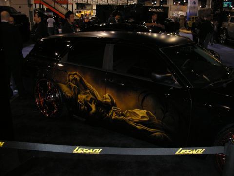 1998 Ford Crown Victoria - Custom airbrushed black car with Lexani wheels displayed at an auto show.