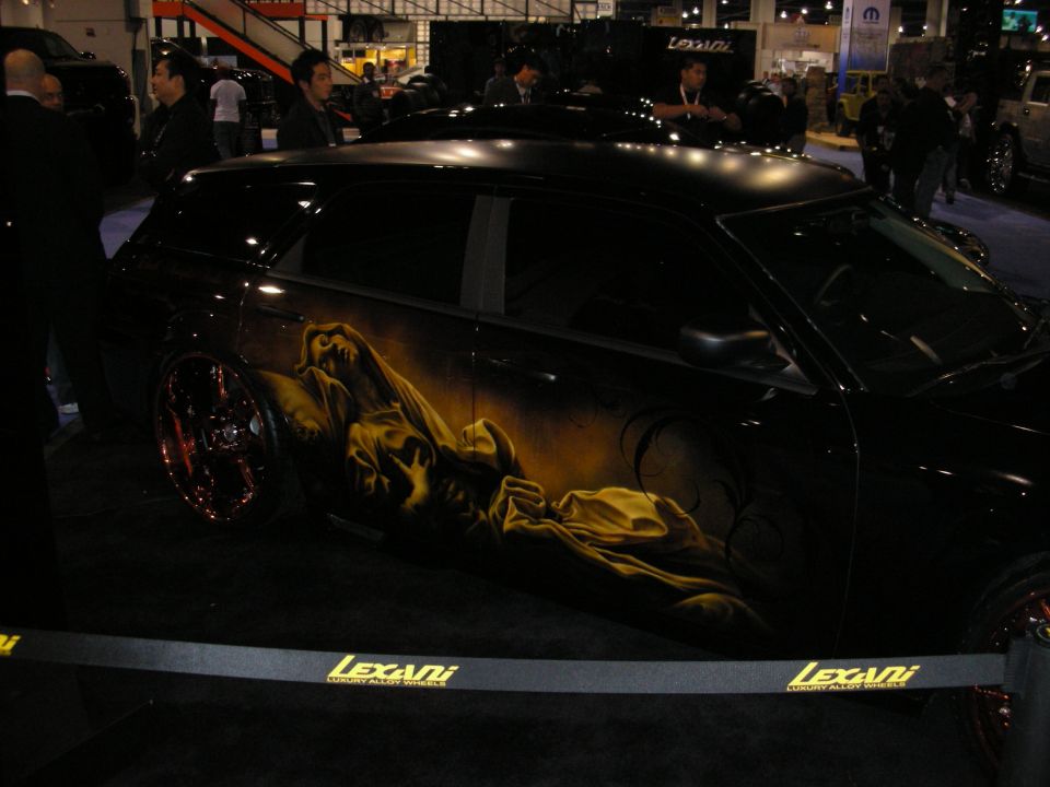 Black car with custom airbrushed artwork on the side, Lexani wheels