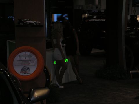 1998 Ford Crown Victoria - A tire display and a dark SUV are visible at an event with two women standing nearby.