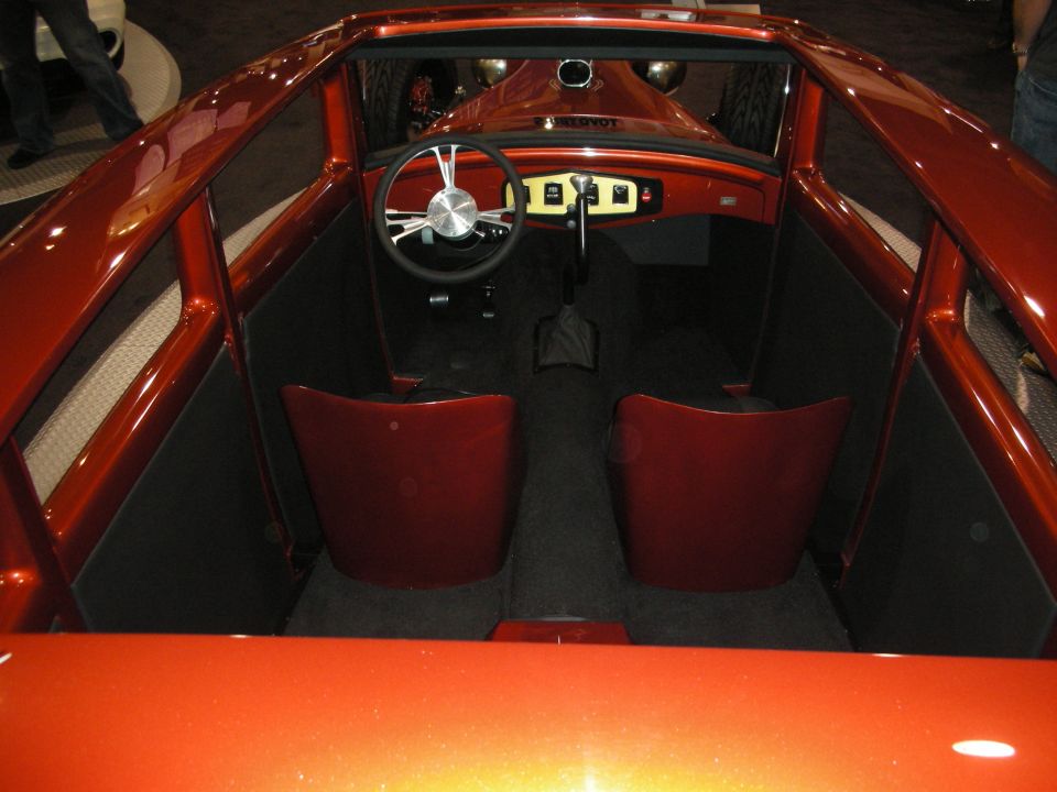 Orange hot rod interior with red bucket seats and custom steering wheel